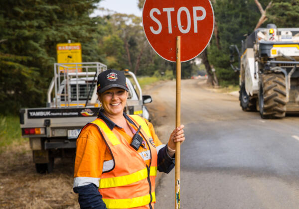 Indigenous traffic controller holding stop sign in Geelong